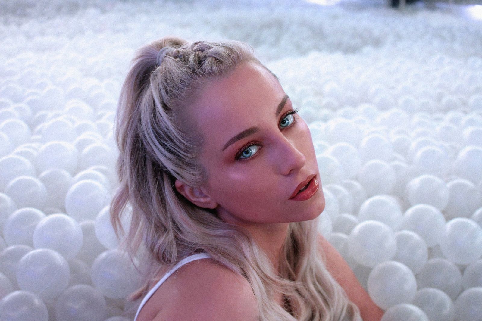 Blonde model in white ballpit studio